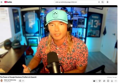 Person wearing mint green cap and patterned shirt speaking into microphone in home recording studio with blue lighting
