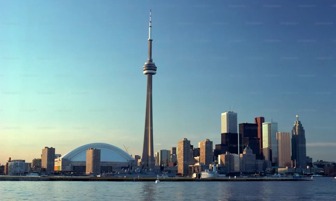 Toronto skyline with CN Tower prominent against blue sky and waterfront view
